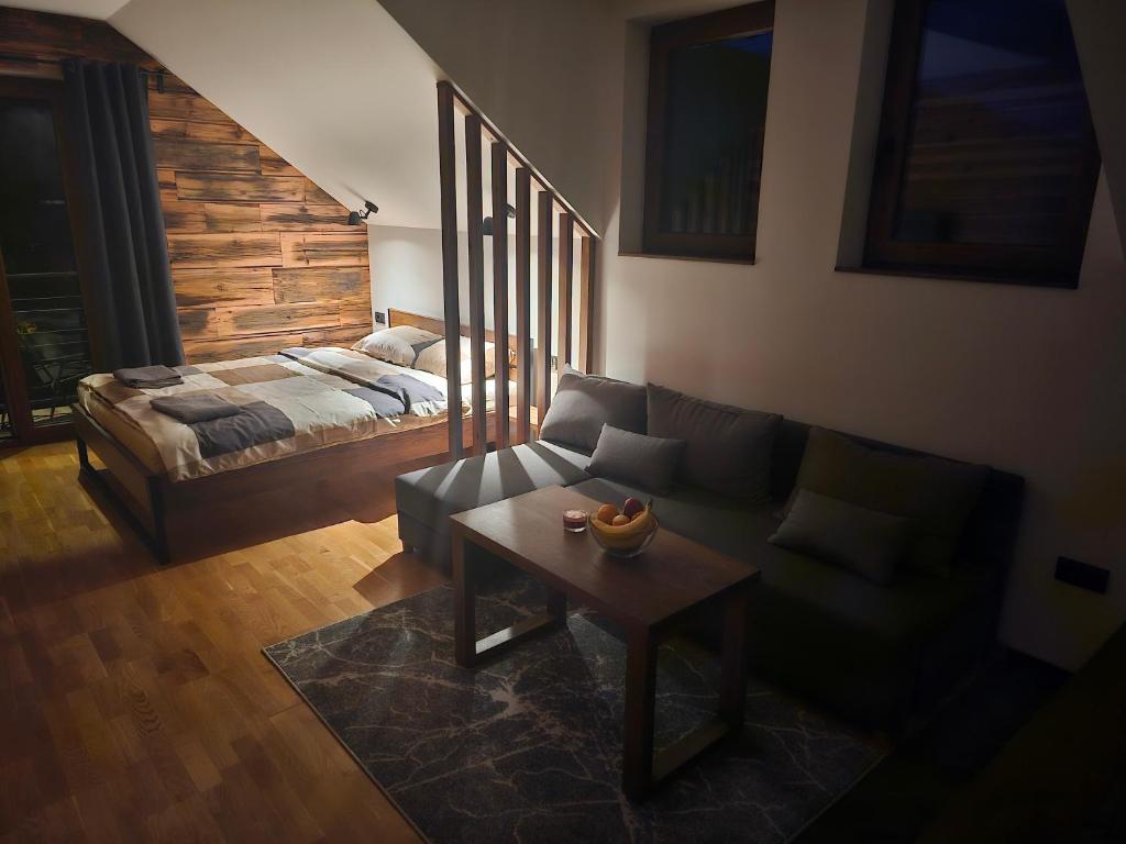 a living room with a couch and a bed at Apartment 112 in Mokra Gora