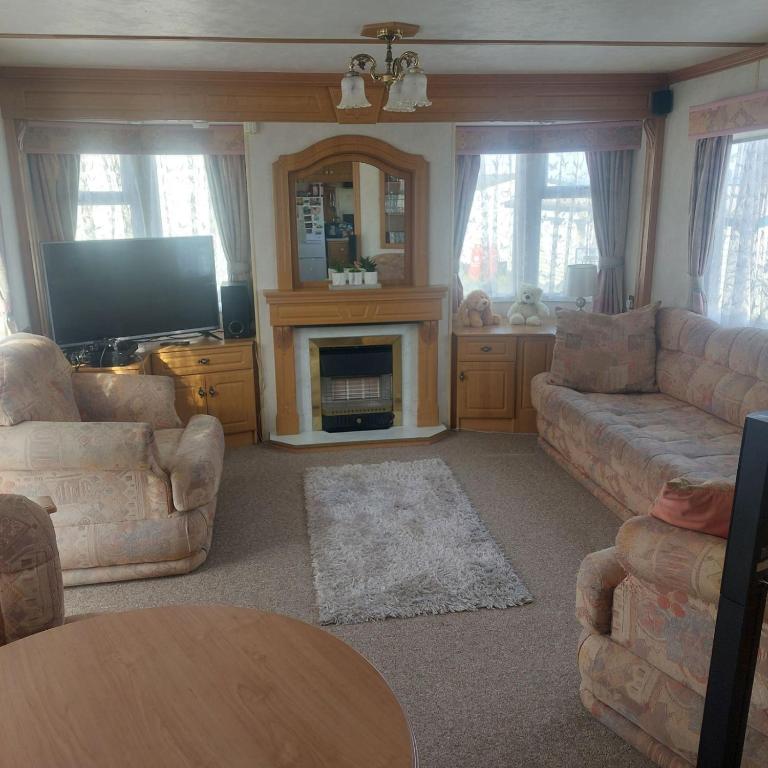 a living room with a couch and a fireplace at warden springs caravan park MS16 Thornhill road, Eastchurch,ME124HF in Sheerness