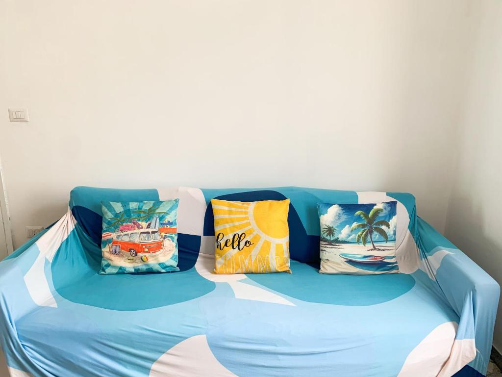 un sofá azul con almohadas encima en Conero-30 mt dal Mare, Balcone V i s t a Mare e Spiaggia di sabbia en Porto Potenza Picena