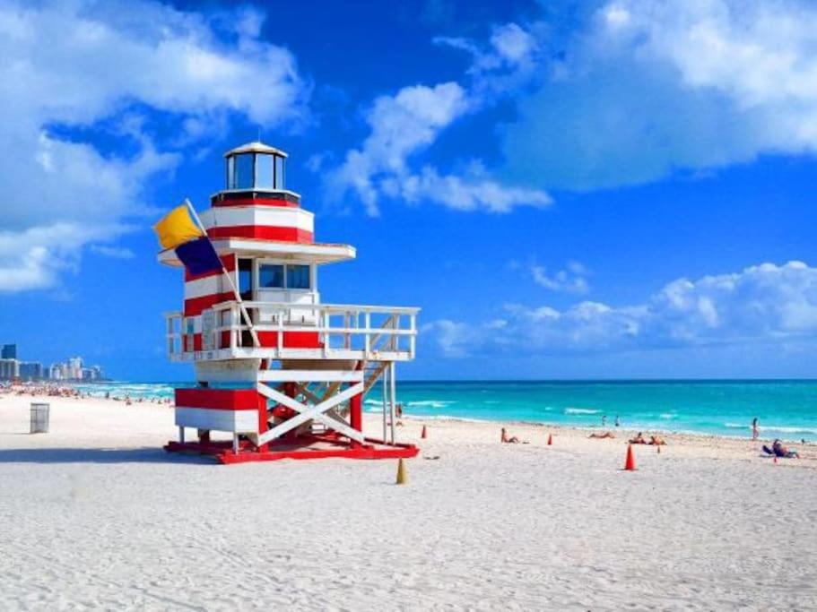 a lighthouse on a beach with people on the beach at APARTMENT RIGHT ON THE BEACH! in Miami Beach