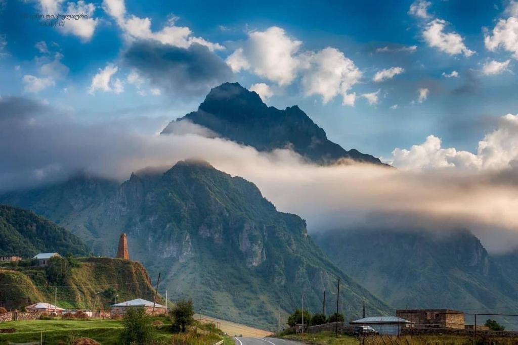 a mountain with clouds in front of it at Cottage Shina in Kazbegi