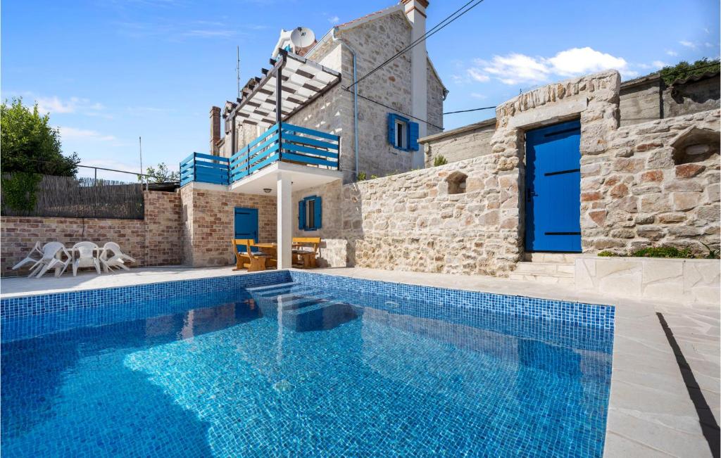 a villa with a swimming pool and a house at Amazing Home In Zlarin With Outdoor Swimming Pool in Zlarin