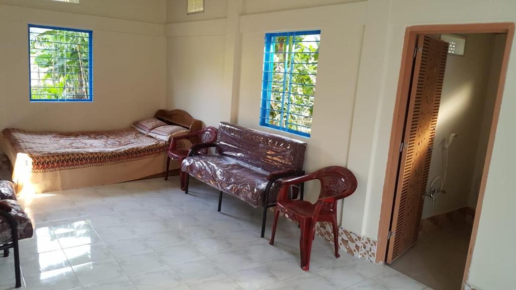 Habitación con sofá, cama y ventanas. en Sunapur Mini Resort Sylhet en Sylhet
