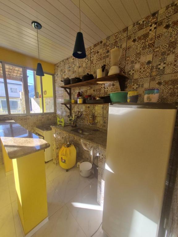 een keuken met een koelkast in een kamer bij Cantinho Feliz de Muriqui / Casa amarela in Mangaratiba