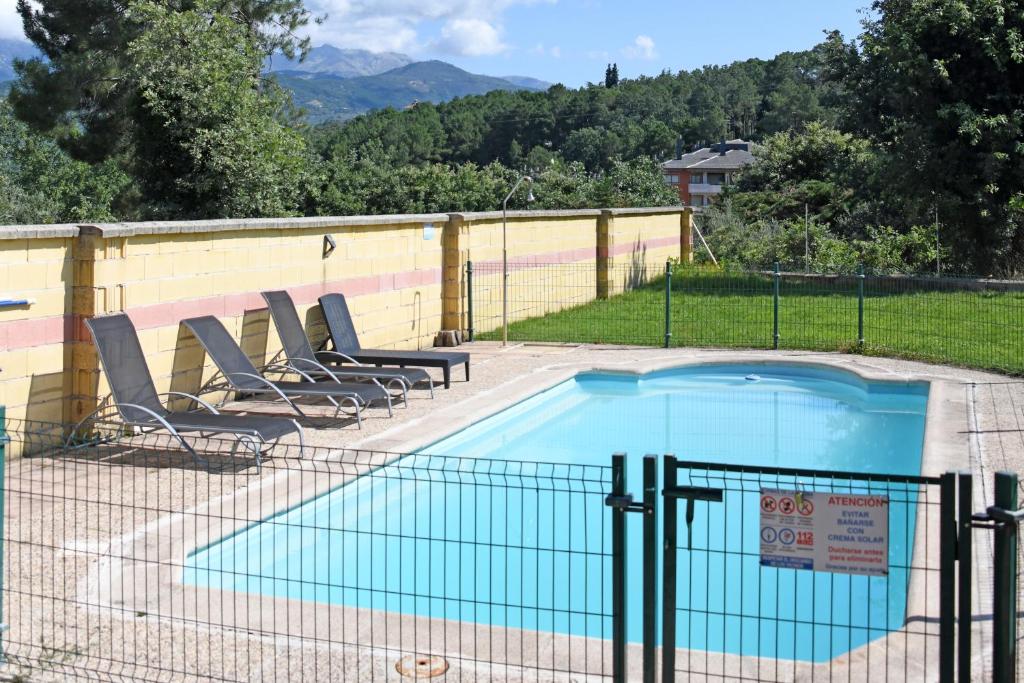 una piscina con sillas y una valla alrededor en EL VALHALLA, TU LUGAR DE DESCANSO EN LA TIERRA., en Arenas de San Pedro