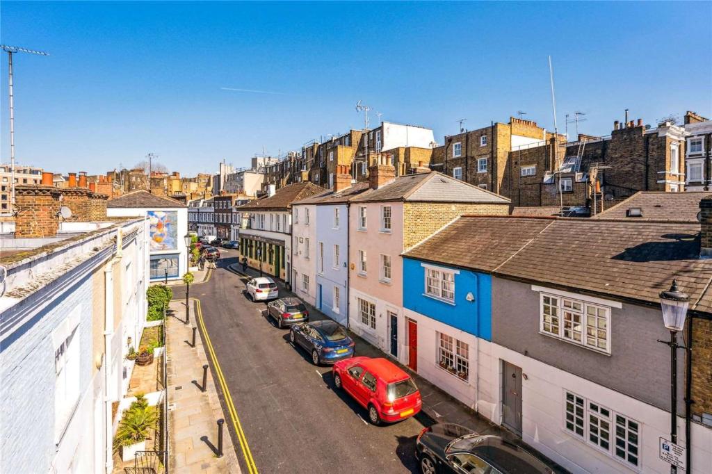 a view of a city with cars parked on a street at Kensington two floor mews house in London
