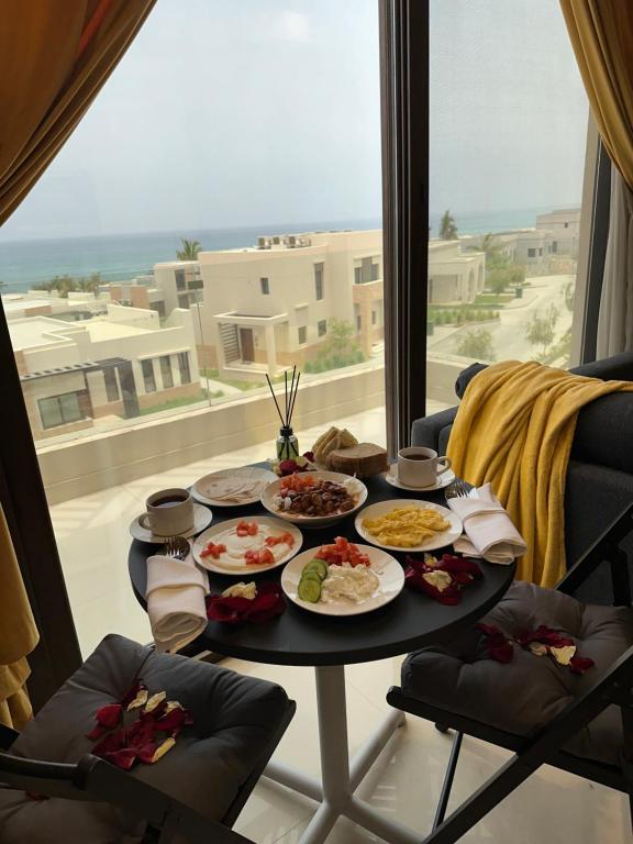 uma mesa com pratos de comida em cima de uma janela em Casa de Amor Sifa em As Sīfah