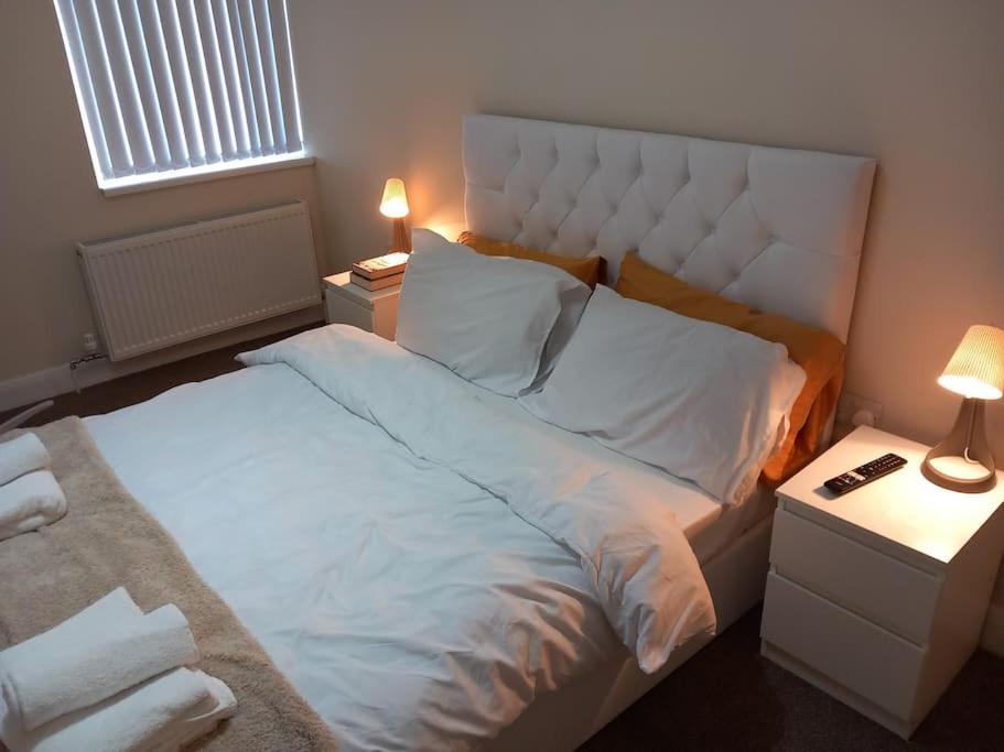 - une chambre avec un grand lit blanc et deux lampes dans l'établissement Beautiful and Cosy 3 beds home for 6 guests near Doncaster Racecourse, 