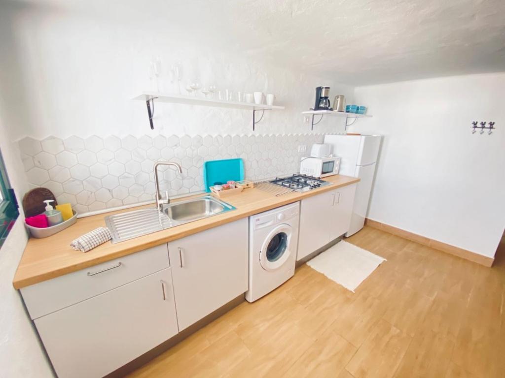 a kitchen with a sink and a washing machine at Casa Gercko 2 in Yaiza