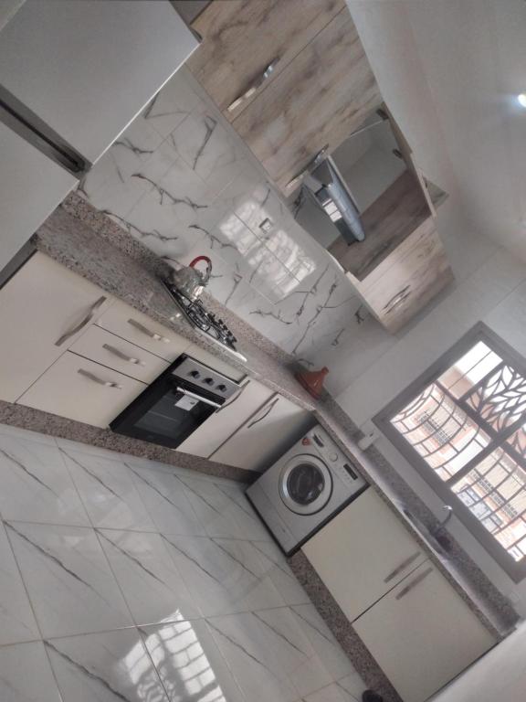 uma vista superior de uma cozinha com uma máquina de lavar roupa em Sweet Room Airport 5 em Deroua