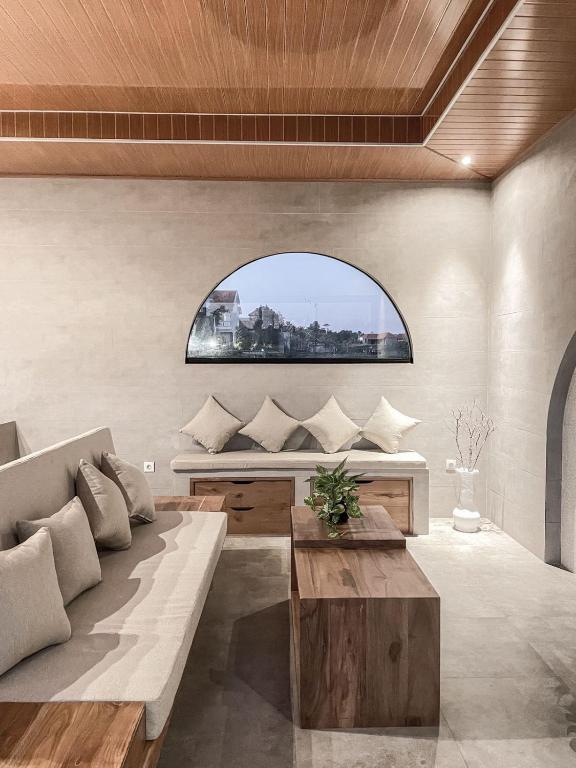 a living room with a couch and a window at Mandevilla Canggu in Canggu