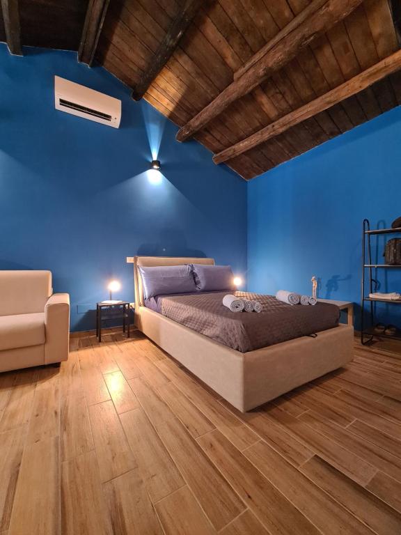 1 dormitorio con paredes azules, 1 cama y 1 silla en Eco&Narciso apartment, en Monreale