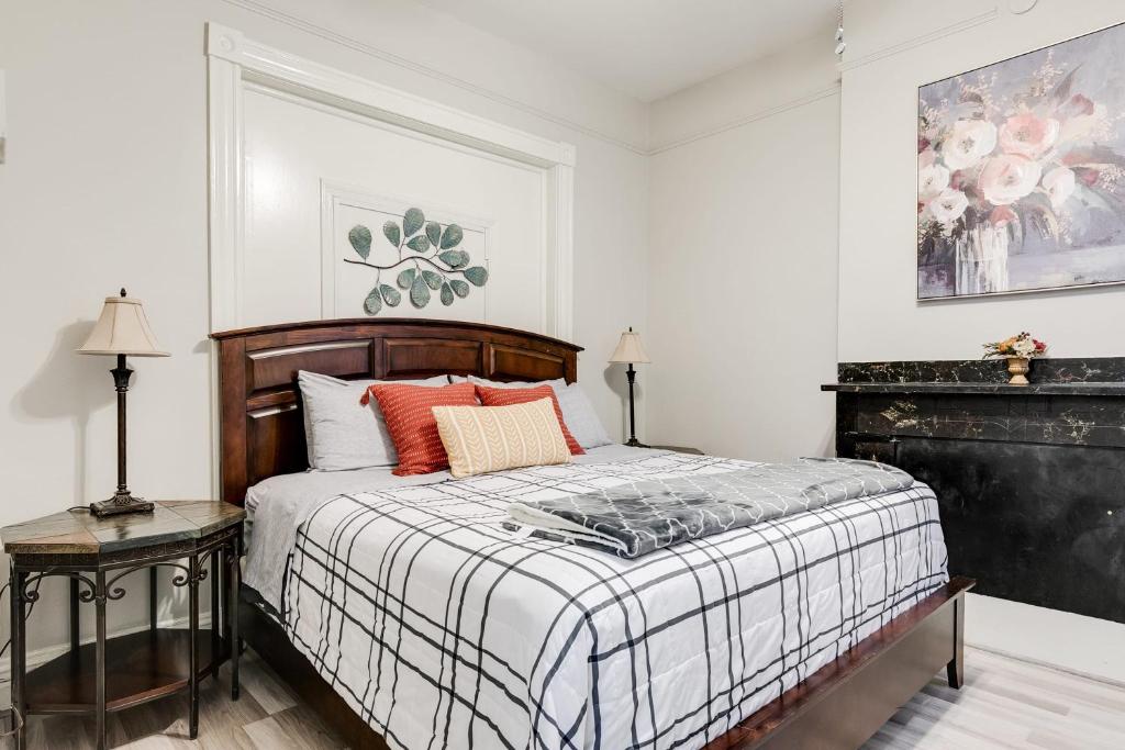 a white bedroom with a bed with orange pillows at M1 central location in the Fan VCU free parking in Richmond