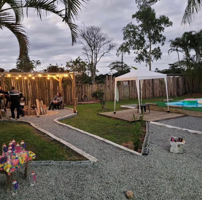 een achtertuin met een tent en een zwembad bij Suítes Recanto Monte trigo in São Francisco do Sul