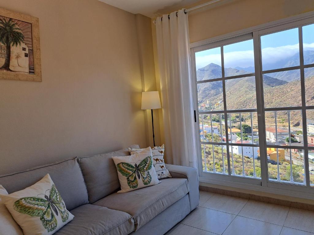 a living room with a couch and a large window at Las Teresitas Apartment in San Andrés