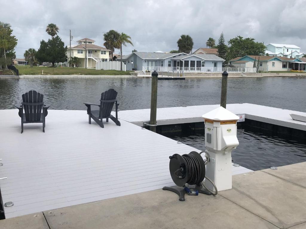 a dock with two chairs and a heater on the water at Waterfront Hernando beach house on deep water canal w/dock, fishing, kayak in Hernando Beach