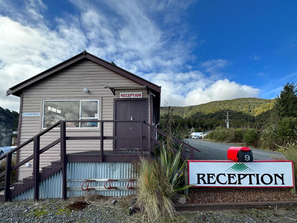 a small house with a sign in front of it at The Crossing Lodge & Backpackers in Erua