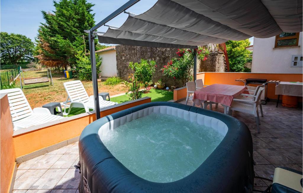 a hot tub on a patio with a table and chairs at Beautiful Home In Pula With Wifi in Pula