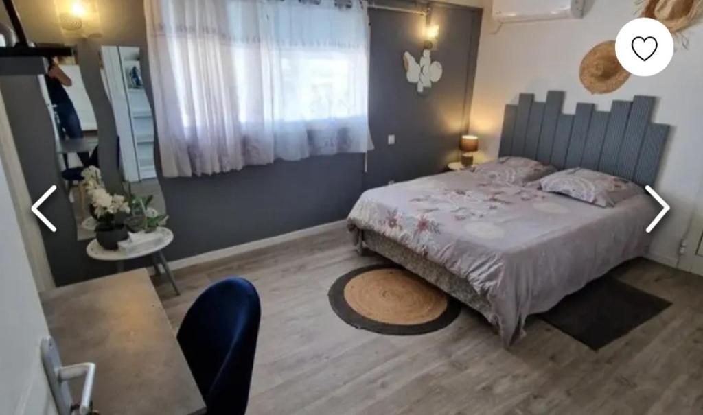 a bedroom with a bed and a table and a window at VILLA LAURAYM in Baie-Mahault