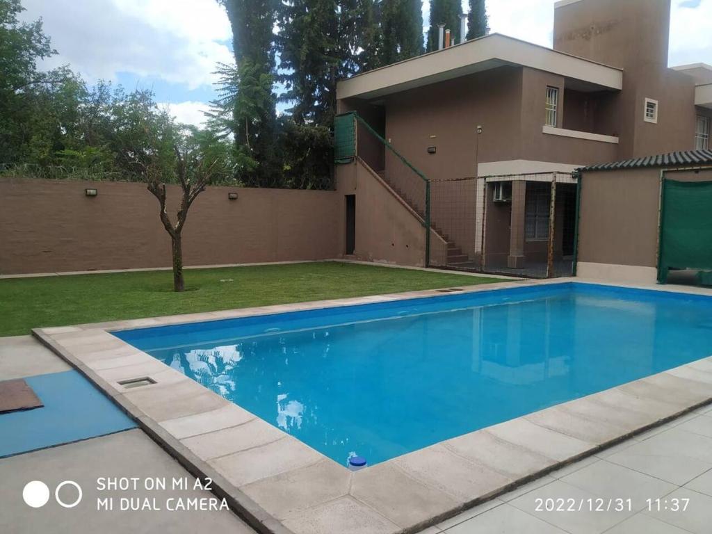 a swimming pool in front of a house at Departamento Brisa Andina in Ciudad Lujan de Cuyo