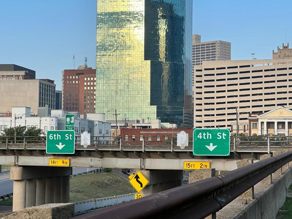 un pont avec des panneaux de rue dans une ville dans l'établissement Stunning 2 bedroom Downtown Ft Worth, à Fort Worth