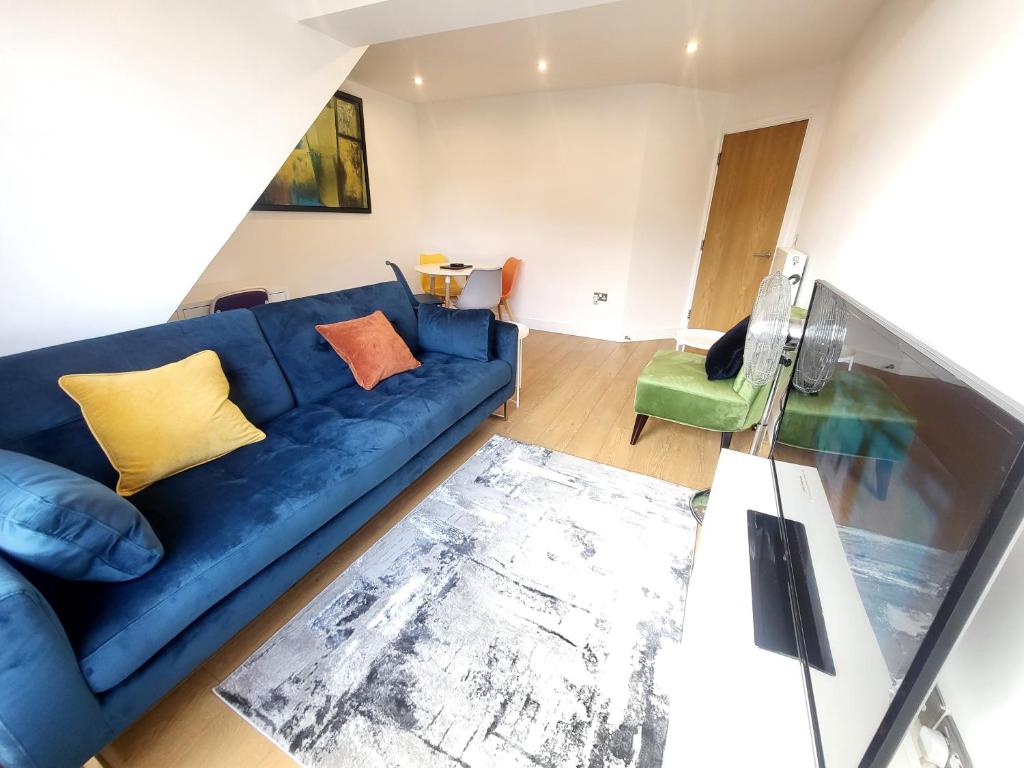 a living room with a blue couch and a green chair at Garland City Centre Apartment, Crayford-Dartford in Crayford