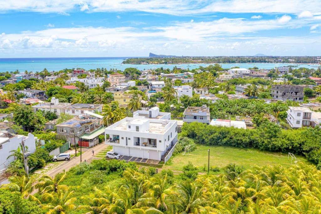 an aerial view of a white house in front of the ocean at Lotus Lane Apartments in Grand-Baie