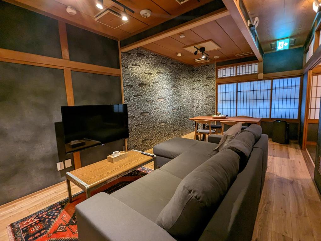 sala de estar con sofá y TV de pantalla plana en SIDOU 　INN en Onomichi
