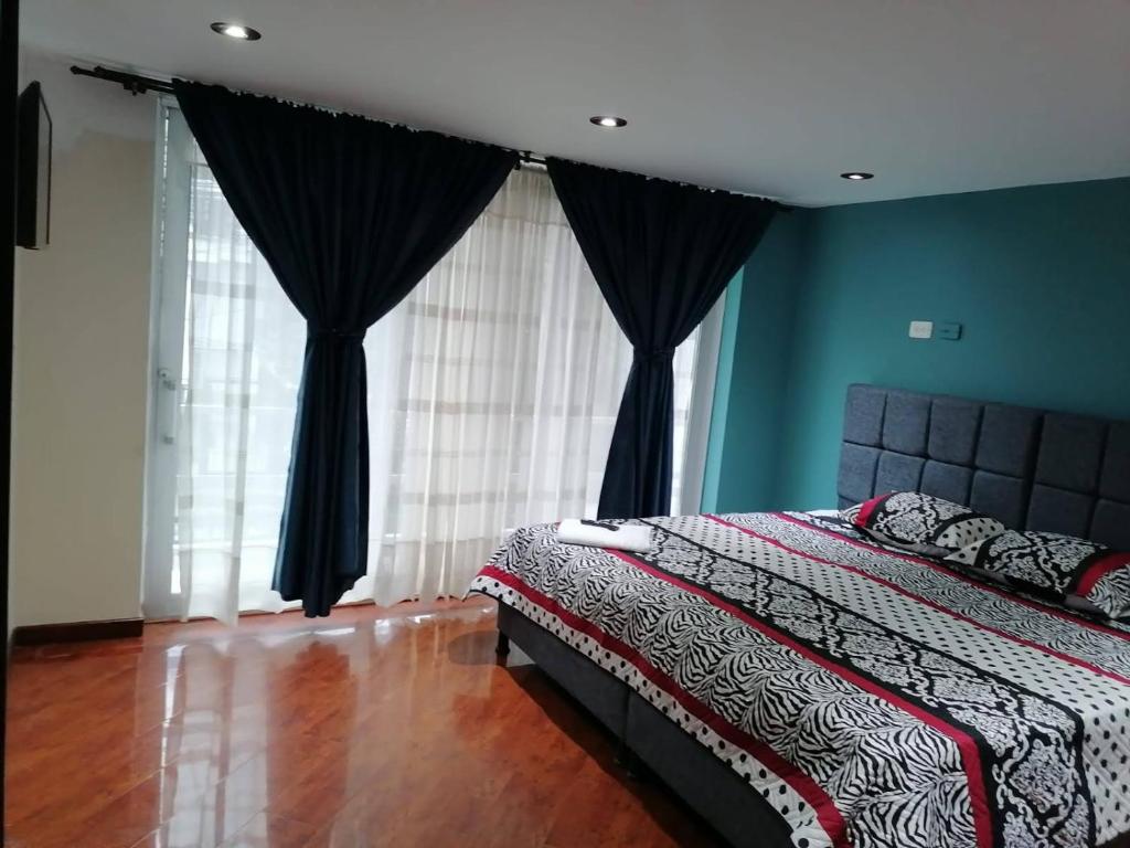 a bedroom with a bed with blue walls and curtains at Cornelio's House in Bogotá