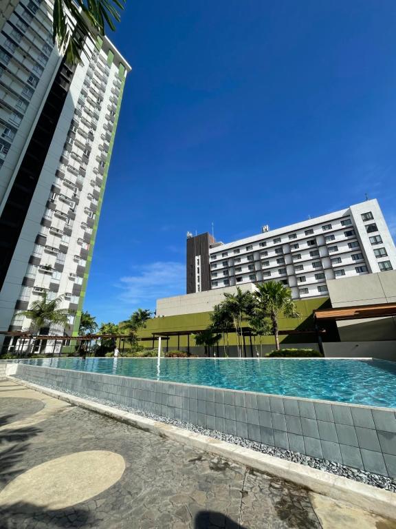 un hôtel avec une piscine en face de deux bâtiments dans l'établissement Condo Beside Ayala Mall - Centrio Tower, à Cagayán de Oro