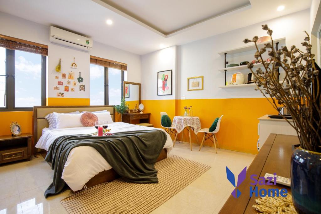 - une chambre avec un lit, une table et des chaises dans l'établissement Sazi Home Cau Giay, à Hanoï
