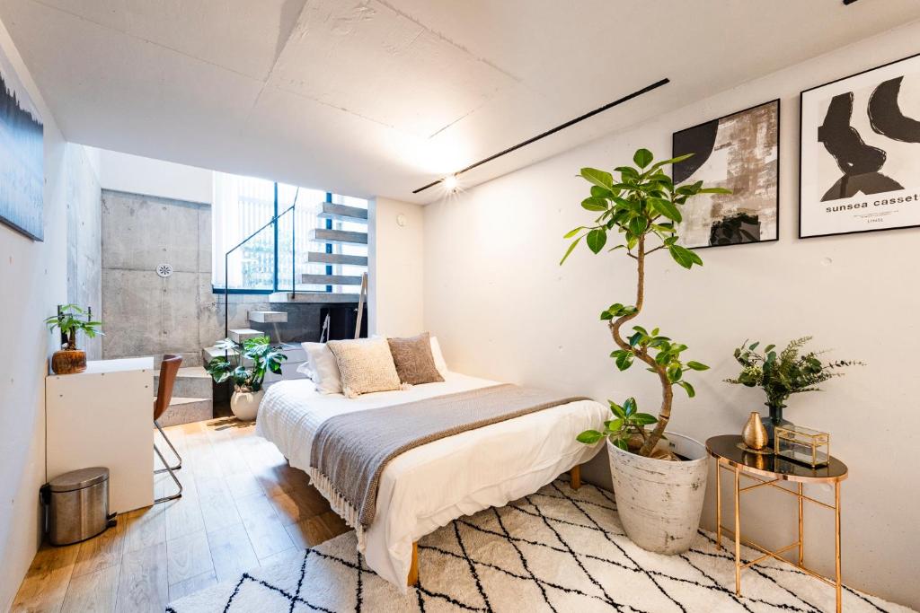a bedroom with a bed and potted plants in it at RiriLeo Koenji in Tokyo