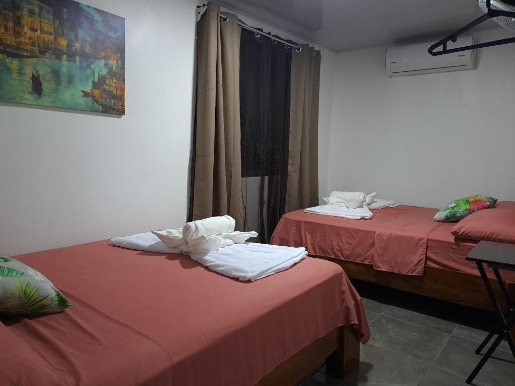 a room with two beds with towels on them at Casa Chu en Playa Manuel Antonio in Manuel Antonio