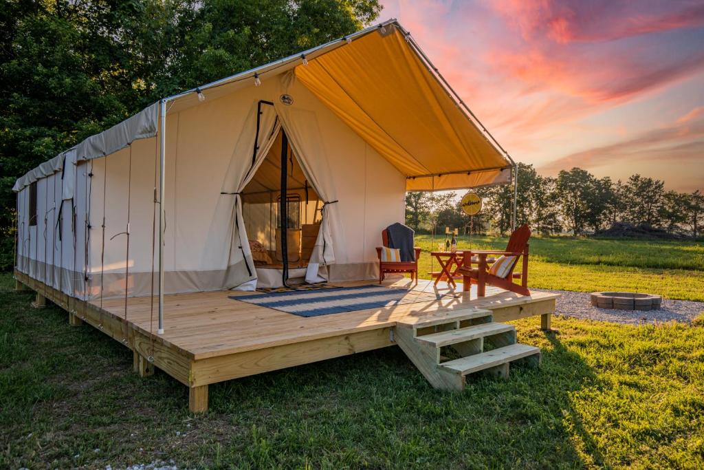 Tienda con terraza de madera y mesa en Roaring River Luxury Glamping #5, en Cassville