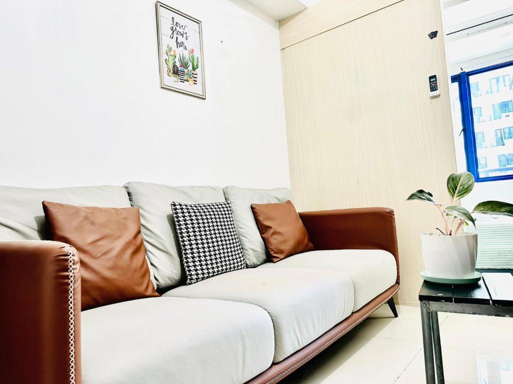 a living room with a couch with pillows on it at Sea Residences - Property Val Alano 0995-448-8872 in Manila