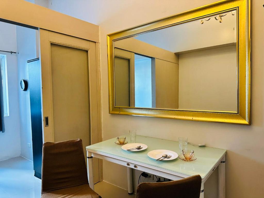 a bathroom with a mirror and a table and chairs at Sea Residences - Property Val Alano 0995-448-8872 in Manila