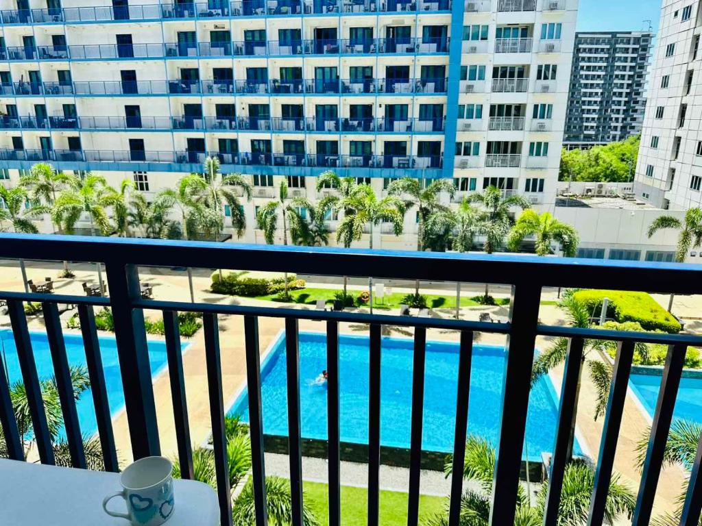 a balcony with a view of a pool and buildings at Sea Residences - Property Val Alano 0995-448-8872 in Manila