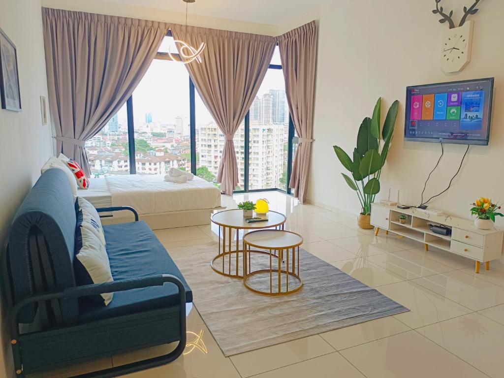 a living room with a blue couch and a tv at Rooftop Pool, 8 Pax, 2 Bedrooms, 2 Bathrooms, 2 Car Parks by Star Home in Jelutong
