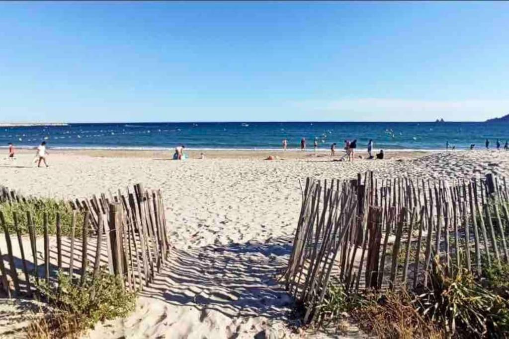 une clôture sur une plage avec des gens dans l'eau dans l'établissement Bel appartement, proche plage les sablettes, à La Seyne-sur-Mer