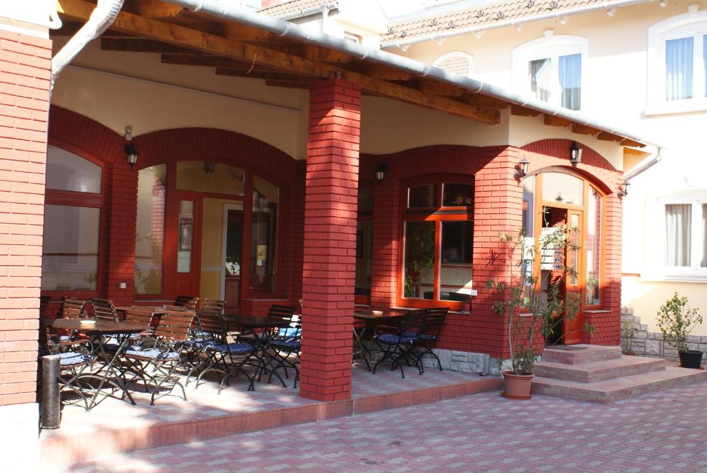 a brick building with tables and chairs on a patio at Hotel Palota City in Budapest