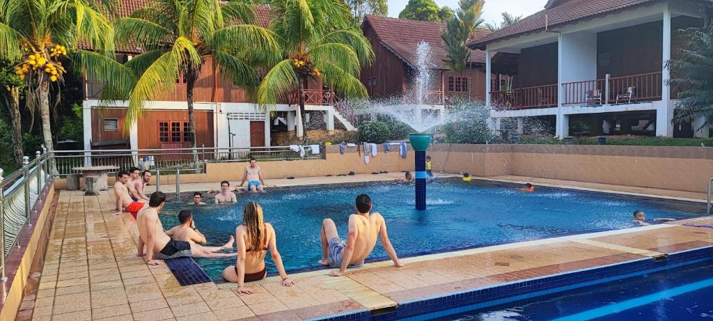 a group of people sitting in a swimming pool at Tekoma Resort Taman Negara in Kuala Tahan