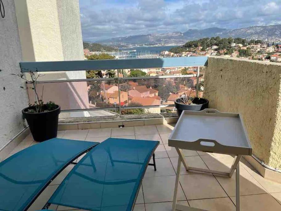 einen Balkon mit einem Tisch und Stadtblick in der Unterkunft Superbe appartement st mandrier à 100mde la plage in Saint-Mandrier-sur-Mer