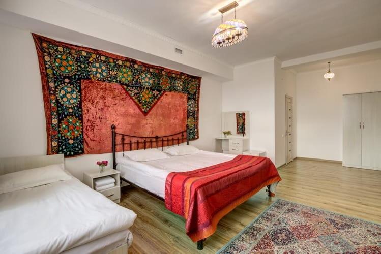 a bedroom with two beds and a large rug at Olive hotel Kochkor in Kochkorka