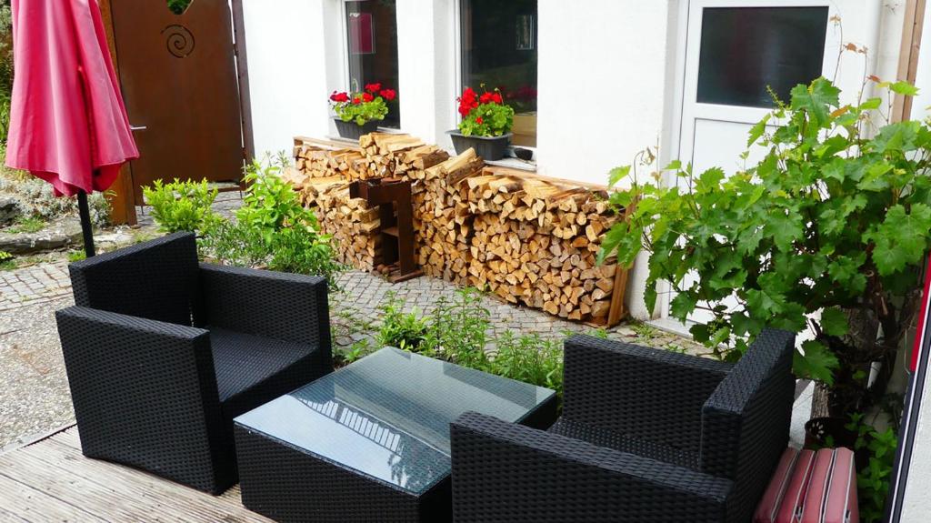 een patio met 2 stoelen, een tafel en een hek bij Atelier Mariaberg in Kempten
