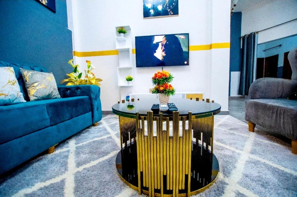 sala de estar con sofá azul y mesa en Appartement meublé en Douala