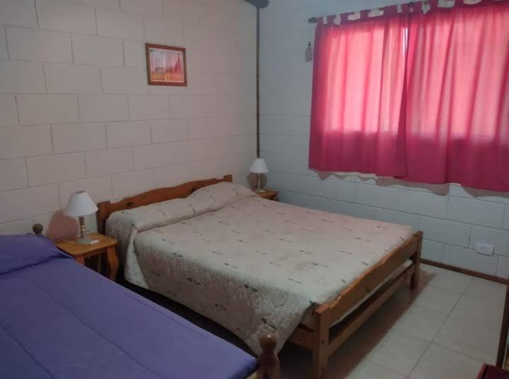 1 Schlafzimmer mit 2 Betten und einem roten Fenster in der Unterkunft Tamya-Waira in Charbonier