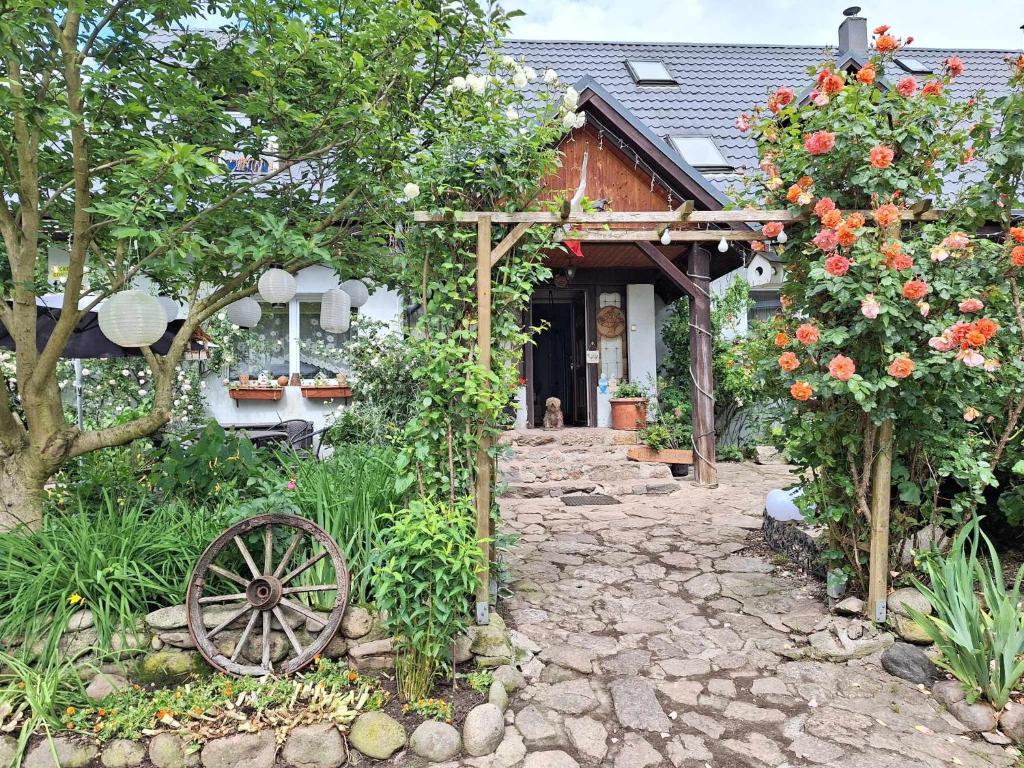 a house with a garden with flowers and a wooden wheel at Michałowa Zagroda in Piechowice