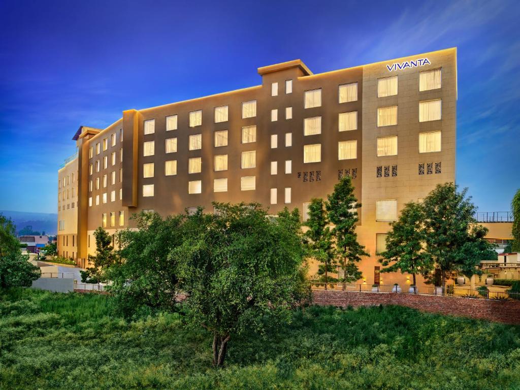 a large hotel building with trees in front of it at Vivanta Jammu City Centre in Jammu