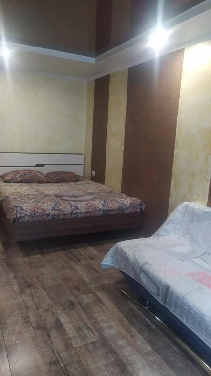 twee bedden in een kamer met houten vloeren bij Кирова А Поля ЖД вокзал in Dnipro