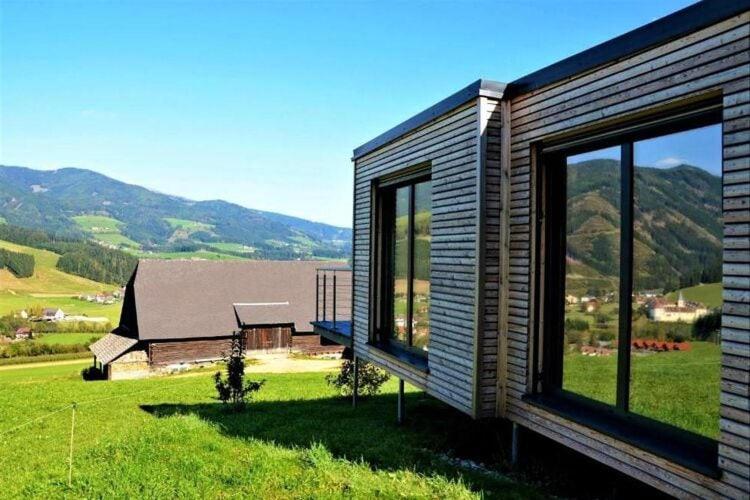 ein Haus mit großen Fenstern auf einem grünen Feld in der Unterkunft 4 star holiday home in Gaal im Murtal in Pirkach
